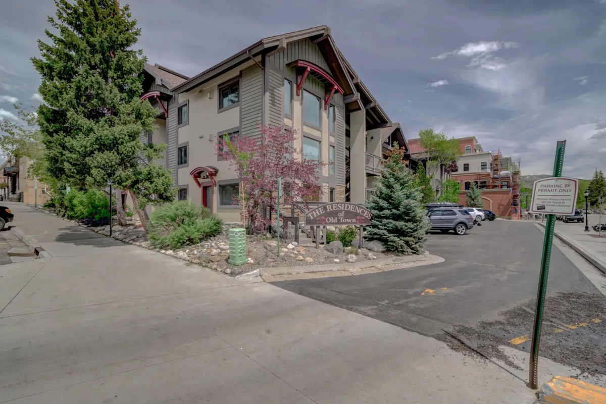 A vibrant exterior view of the building's facade with clear signage and manicured landscaping, suggesting a lively, community-oriented environment perfect for families. Seasonal decorations and hints of community events reflect downtown's active spirit.